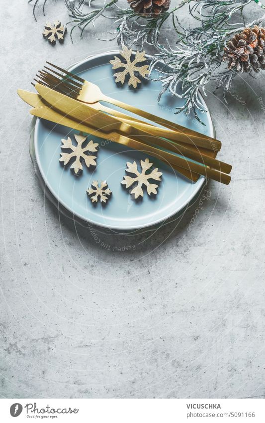 Christmas table setting with golden cutlery , blue plate and snowflakes decoration , top view christmas overhead celebration december event festive fork holiday
