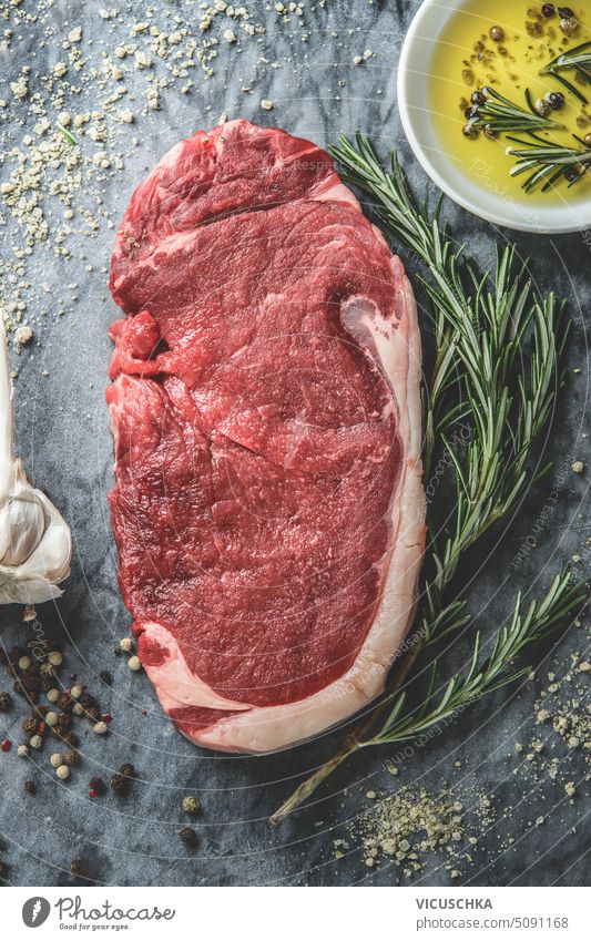Close up of raw meat beef steak with herbs , spices and cooking oil on marble stone background, top view close up black angus chop closeup food fresh ingredient