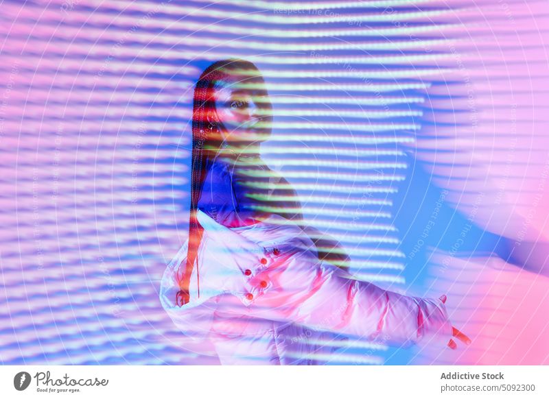 Stylish ethnic female youngster standing in neon studio woman confident cool style self assured serious move model glow individuality african american black