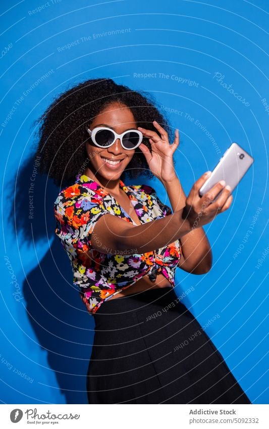 Stylish African American female taking selfie woman smile style smartphone adjust sunglasses happy colorful bright young black african american ethnic modern