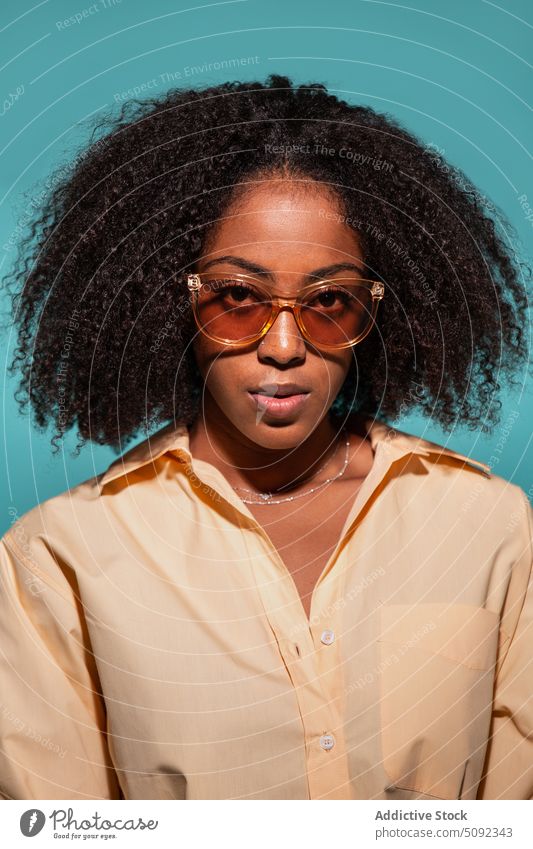 Stylish black model in shirt and sunglasses woman style appearance curly hair serious portrait colorful bright female african american ethnic young