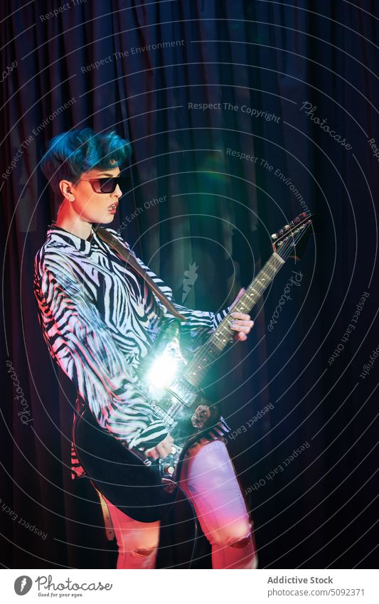 Stylish woman playing guitar in studio electric music musician guitarist fashion sunglasses instrument melody sound female perform modern hobby talent rhythm