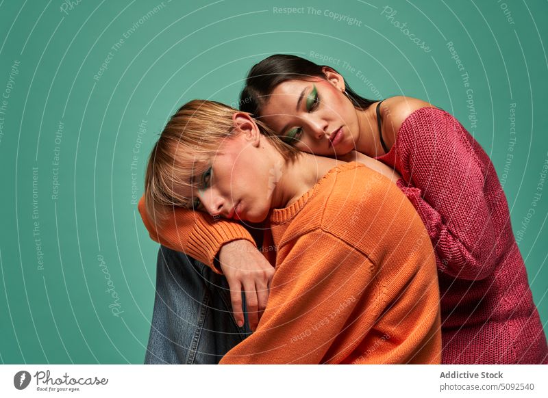 Genderqueer models leaning on each other together style genderqueer non binary androgynous bright colorful sensual man woman outfit sweater individuality lgbt