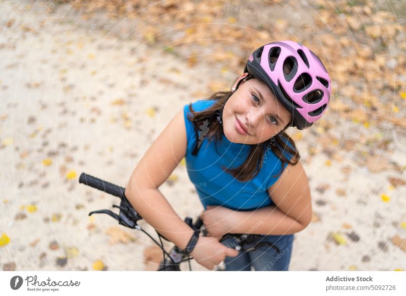 Happy girl leaning on bike handlebar lean on child bicycle autumn park hobby safety happy joy smile young active adrenalin extreme forest ride red vehicle sport