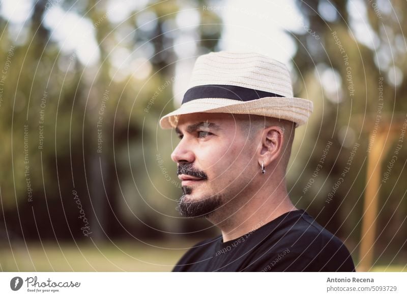 bald man wearing a hat on a spring day caucasian goatee piercing latino spanish one person exterior lifestyle people adult attractive smiling mid adult brown