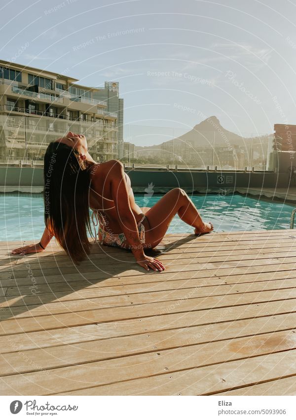 Woman lolling in bikini by pool overlooking Lions Rock in Cape Town Bikini lions rock Hotel vacation Summer Relaxation Lifestyle pretty youthful Lounge tanned