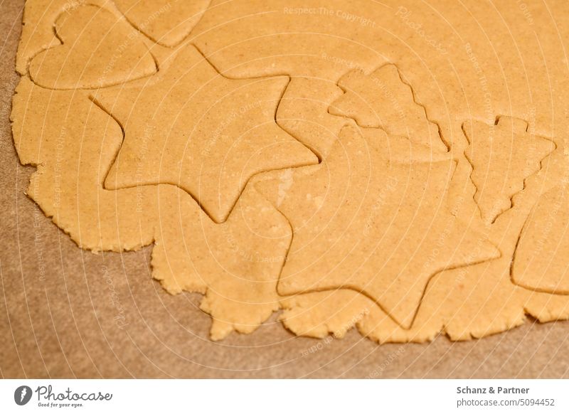 cut out raw dough in the shape of a star for Christmas cookies on baking paper Christmas biscuit biscuits Cookie Baking Christmas & Advent cut out cookies cute