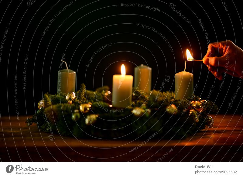 Light Advent wreath Christmas wreath Ignite Match advent season Pensive Anticipation Moody Christmassy Placeholder Copy Space Hand