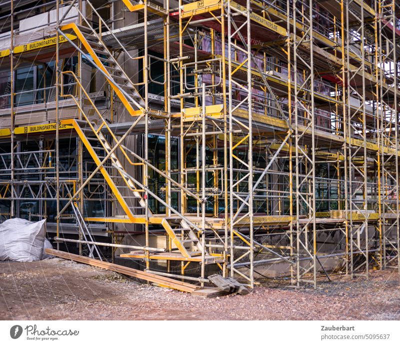 Construction site, scaffolding or scaffolding with stairs, in yellow Scaffolding staircases Yellow Build erection housing Facade Redevelop Modernization work