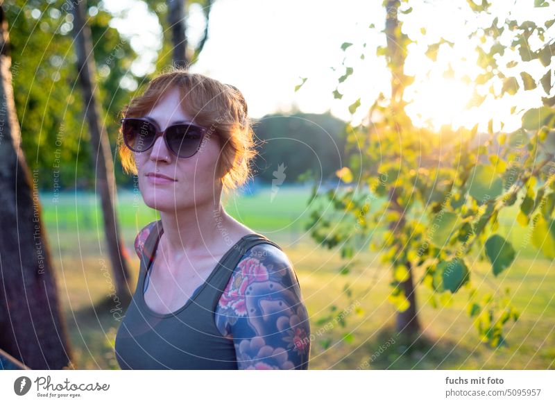Woman with sunglasses and tattoo in sunset Tattoo tattooing Tattooed Sunglasses Back-light vintagelens bokeh lensflair Nature leaves Summer Human being portrait