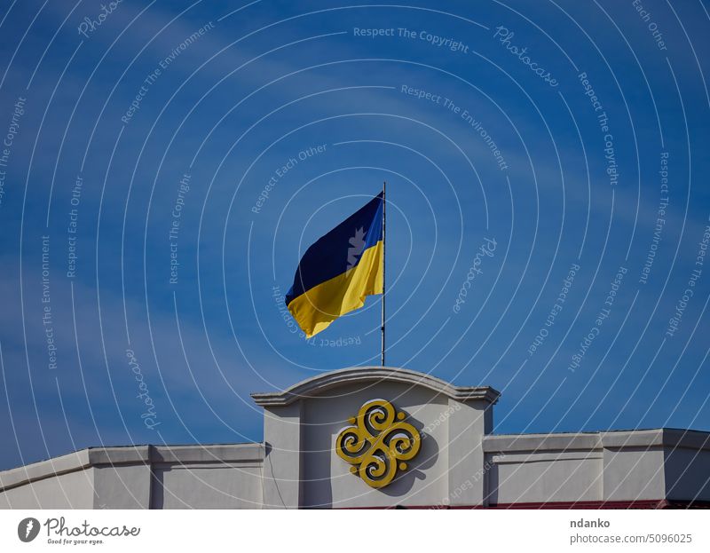 The yellow-blue flag of Ukraine is flying on a building in Kherson against the blue sky kherson pole freedom clear country culture east eastern europe european