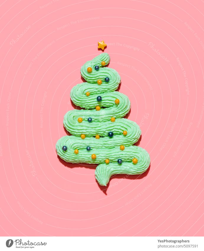 Christmas tree made from buttercream frosting isolated on a pink background above abstract banner baubles candy celebration christmas color concept