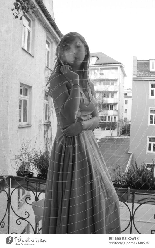 Frau im Abendkleid raucht auf dem Balkon in schwarz weiß schön hübsch lifestyle portrait lange haare jung rauchen blond schwarz-weiß Rauch Elegant Freiheit