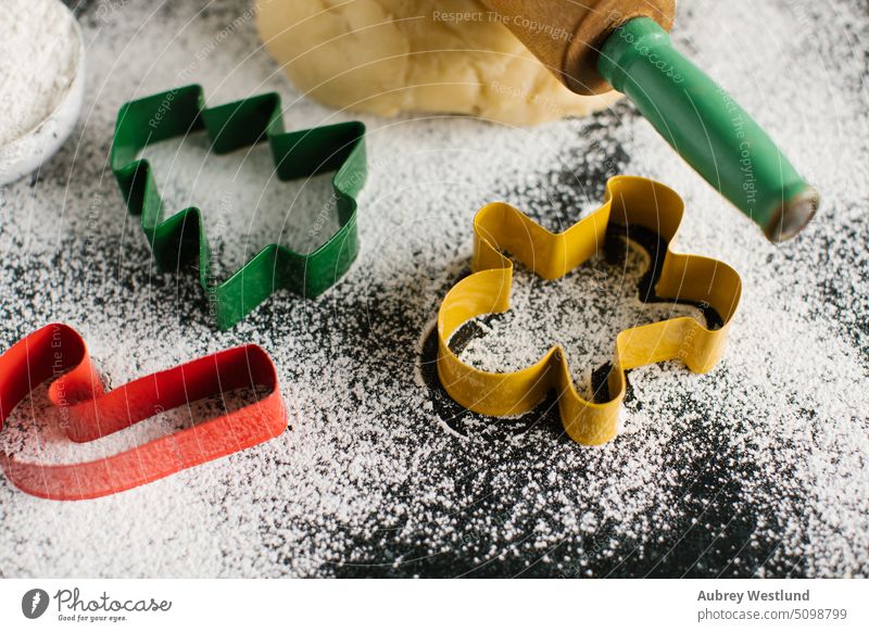 Colorful Christmas shaped cookie cutters on a flour dusted table bake baking candy cane celebration childhood children christmas christmas tree closeup dessert