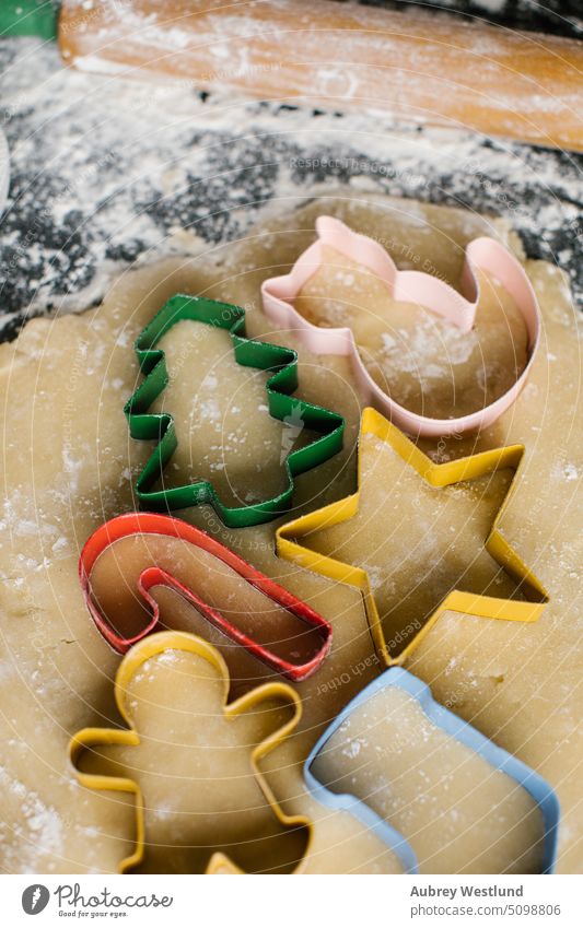 Colorful Christmas cookie cutters arranged on rolled out dough bake baking sheet black candy cane celebration childhood children christmas christmas tree