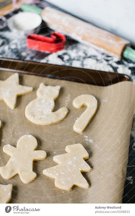 Freshly cut sugar cookies arranged out on a cookie sheet bake baking baking sheet black candy cane celebration childhood children christmas christmas tree