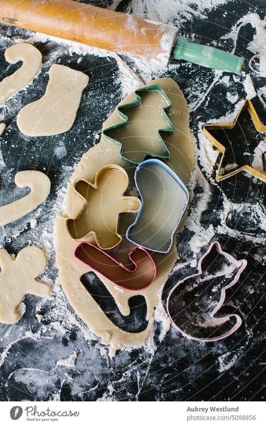 Colorful Christmas cookie cutters arranged on rolled out dough bake baking baking sheet black candy cane celebration childhood children christmas christmas tree
