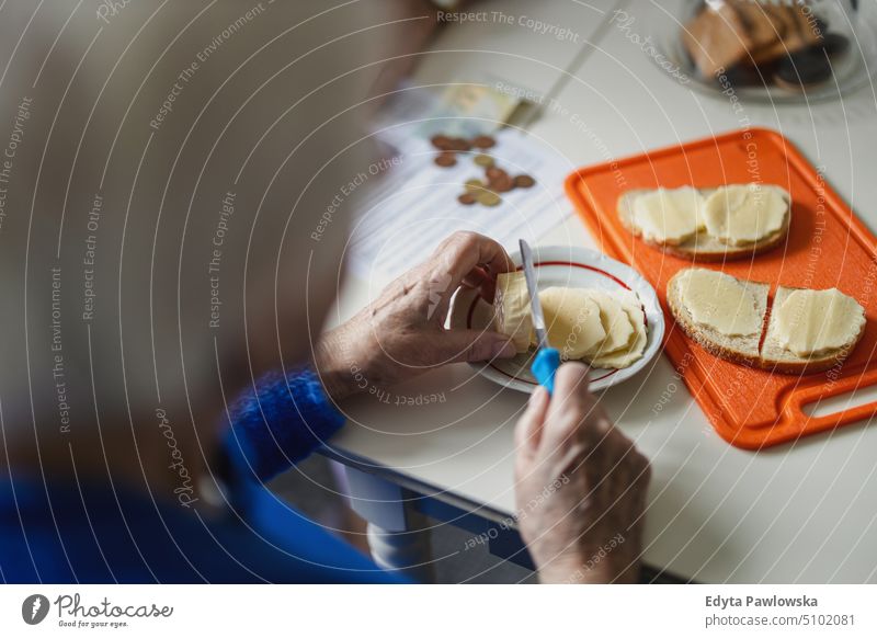 Close-up of the hands of an elderly woman making sandwiches in the kitchen people senior mature female home house old aging domestic life grandmother pensioner