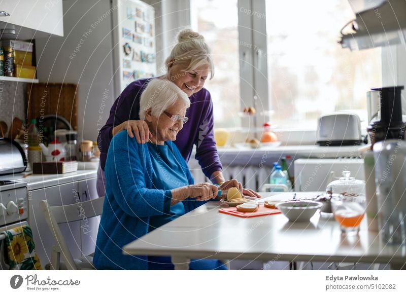 Woman spending time with her elderly mother at home smiling happy enjoying positive people woman senior mature female house old aging domestic life grandmother