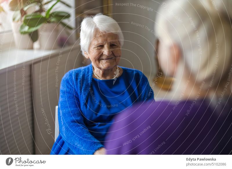 Woman spending time with her elderly mother at home smiling happy enjoying positive people woman senior mature female house old aging domestic life grandmother