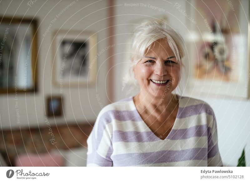 Portrait of a senior woman in her home smiling happy enjoying positive people mature female elderly house old aging domestic life grandmother pensioner retired