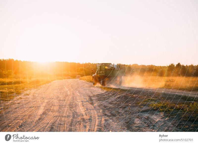Truck Transporting Garbage On Country Sandy Road During Sunset Sunrise Time cargo transport way motion outdoor garbage drive scene truck summer sandy dust