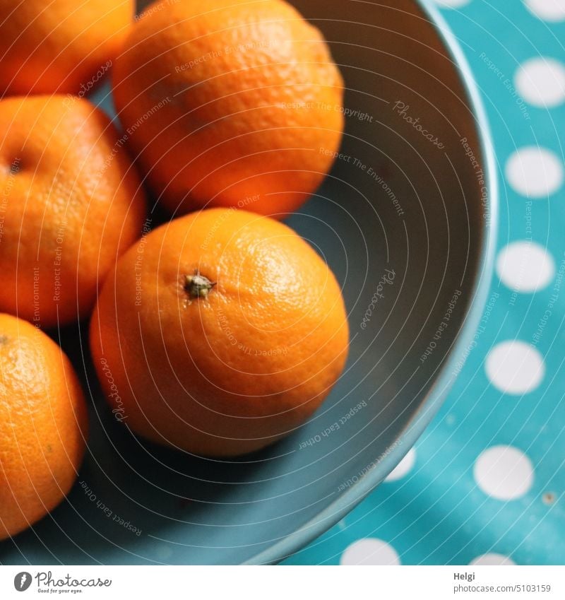 Clementines lie in a turquoise bowl, underneath a turquoise tablecloth with white dots fruit clementine Tangerine Orange citrus fruit Fruit vitamins