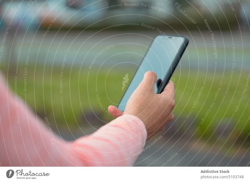 Crop person using cellphone on blurred background woman smartphone surfing internet street message social media gadget connection female browsing online mobile