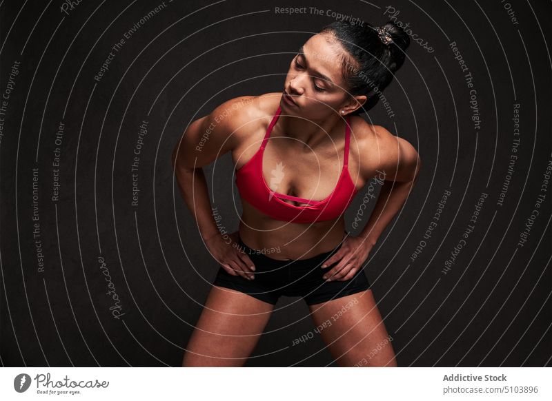 Muscular woman with hands on waist sportswoman hand on waist figure body wellbeing physical studio shot athlete fitness sporty latin hispanic ethnic shape