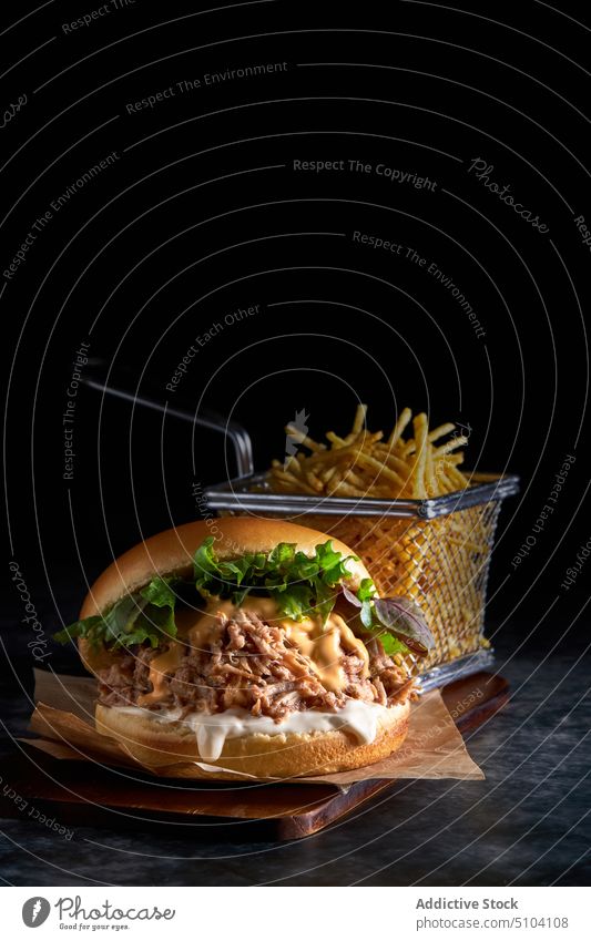 Delicious burger placed on table with French fries serve french tasty junk food fast food meal yummy culinary brioche bread unhealthy mayonnaise pork