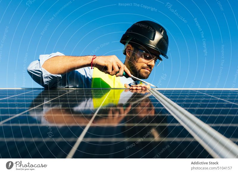 Solar panel installer at work man technician photovoltaic solar panel renewal screwdriver sustainable alternative eco friendly worker male energy professional