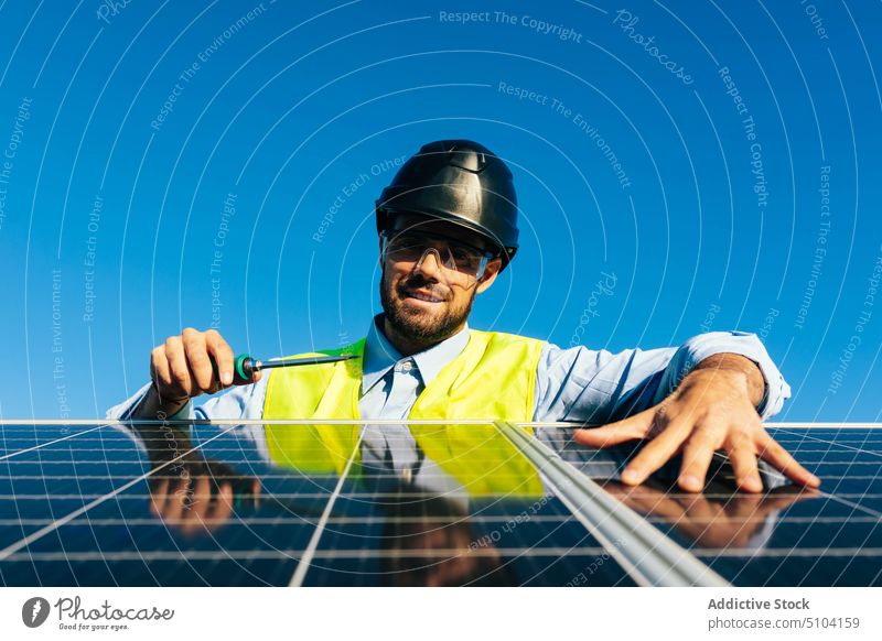 Solar panel installer at work man technician photovoltaic solar panel renewal screwdriver sustainable alternative eco friendly worker male energy professional