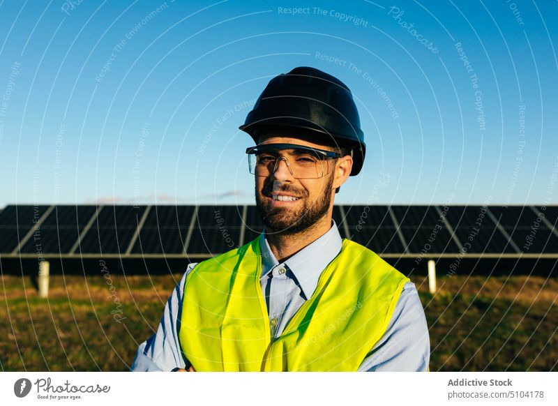 Technician against solar panels in field portrait man technician photovoltaic sustainable alternative eco friendly energy dreamy male relax renewal professional