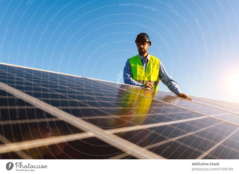 Worker with photovoltaic cells on sunny day man solar panel technician renewal sustainable alternative eco friendly energy male battery installation worker