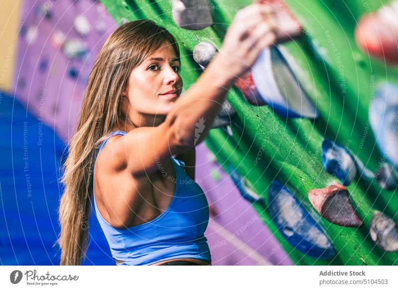 Female athlete on climbing wall sportswoman grip gym training bouldering strong tilt effort female grasp hang activity extreme challenge stamina motivation