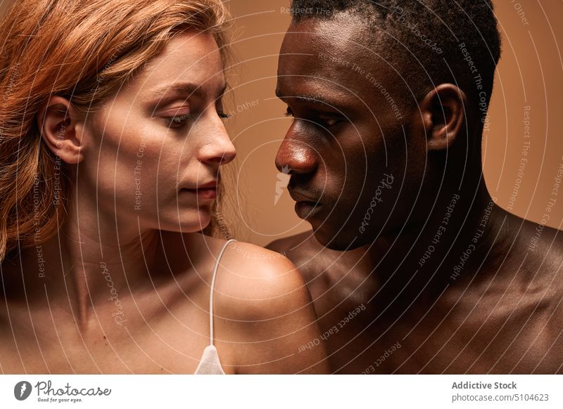 Loving multiethnic couple looking at each other in studio boyfriend girlfriend tender embrace hug relationship face to face fondness love in love together