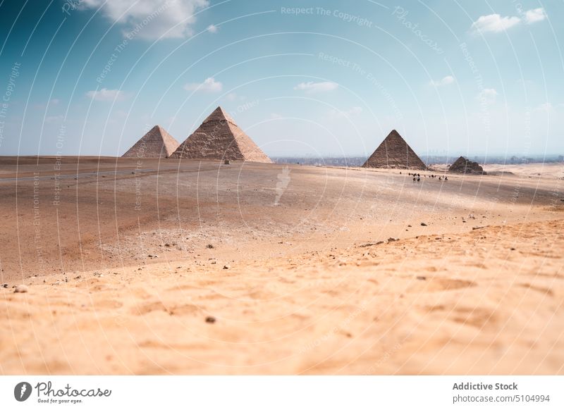 Sandy desert terrain with pyramids landscape sightseeing sand landmark monument heritage egypt ancient arid nature valley sunshine drought blue sky dry masonry