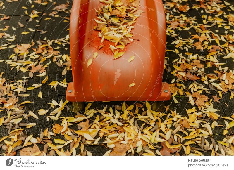 Red slide with yellow leaves Yellow Autumn Autumn leaves fall autumn mood foliage Autumnal colours Early fall autumn leaves leaf nature Park Playground