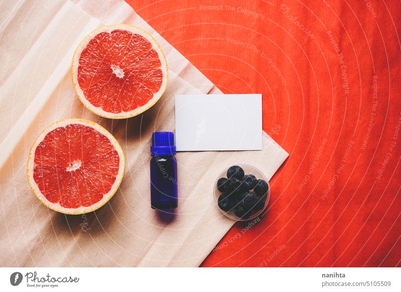 Product image of a business card mockup for organic cosmetics business background flat lay paper grapefruit essential oil blueberries blueberry color red orange