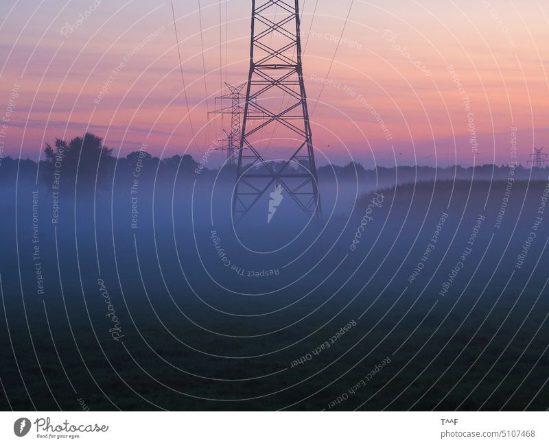 The energy awakens - high voltage overhead line in the morning fog at sunrise Electricity pylon lattice mast Pole power supply energy revolution nebulous