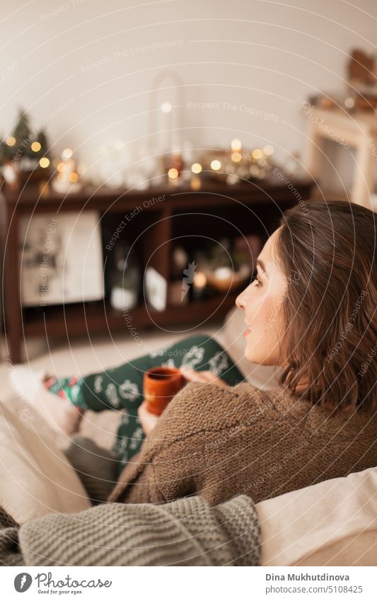 Beautiful caucasian woman smiling at her cozy home apartment leaning over the couch. Casual lifestyle female portrait. Millennial living. Expat life. Creating comfortable space around you.