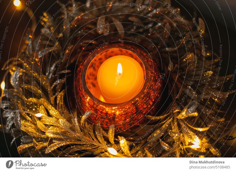 Golden shiny festive candle with burning flame as home decor. Christmas holiday decoration in winter. Interior design details. Flat lay. View from above. golden