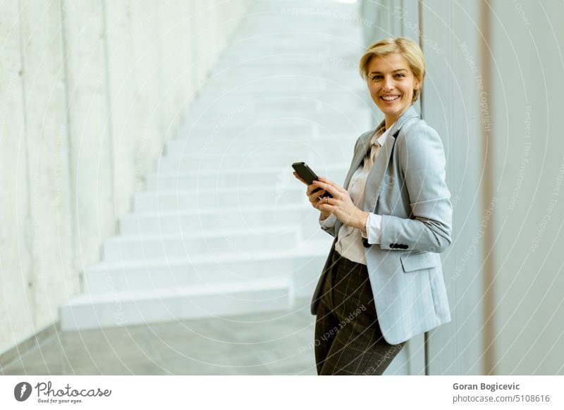Business woman using cell phone in a modern office hallway more adult Attractive Beauty & Beauty Brunette Business person Businesspeople Businessman