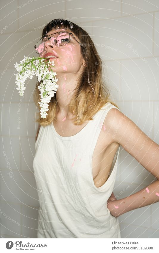 A gorgeous girl with white flowers in her mouth and covered in pink stuff is flirting with a camera. Her sexy curves are undeniable. A wild model test in a toilet.
