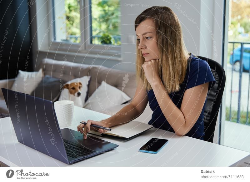 Woman working remotely from home office, using laptop woman typing online keyboard freelancer workplace business technology female computer table education