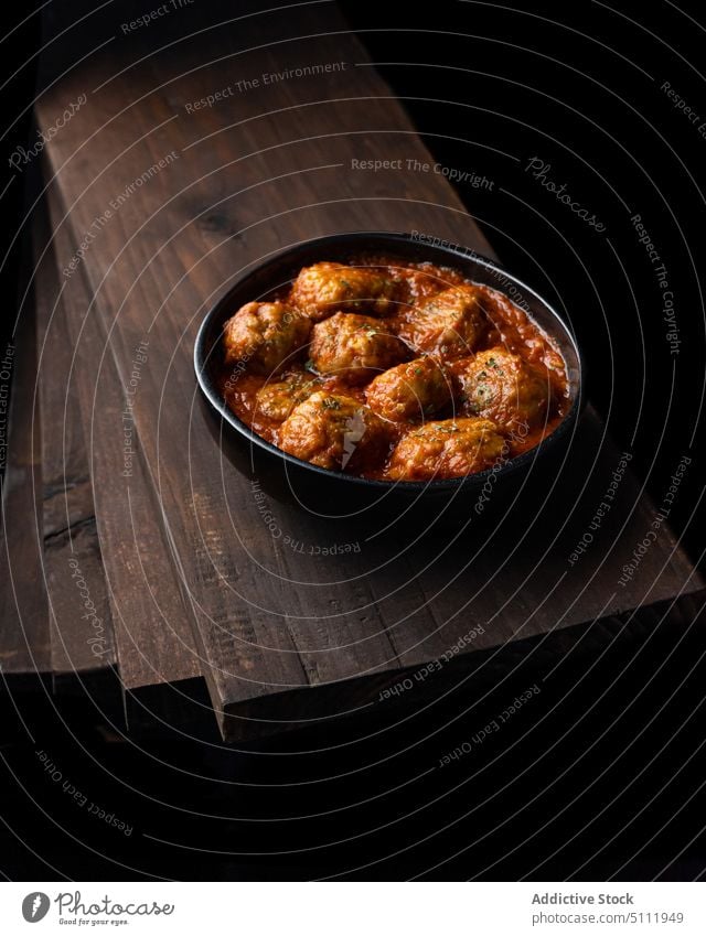 Delicious meatballs in tomato sauce food bowl delicious dish board dark cuisine tasty herb yummy meal pile wooden heap room gourmet appetizing culinary