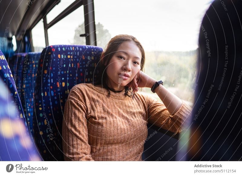 Young woman sitting in bus serious passenger ride road commute calm casual young vehicle transport seat public female noto sicily italy trip asian contemporary