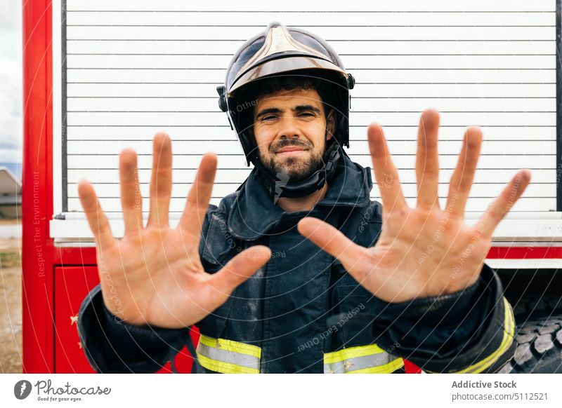 Male firefighter showing dirty hands fireman uniform truck professional emergency soot portrait male adult hispanic ethnic fire engine demonstrate work worker