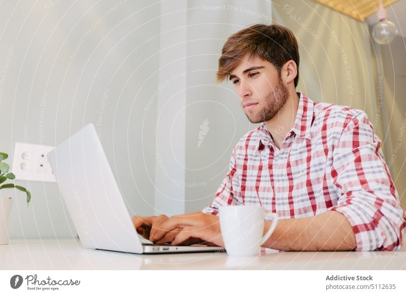 Young Man Working at the Office adult business businessman computer confident cup entrepreneur handsome hipster job laptop male modern office people person