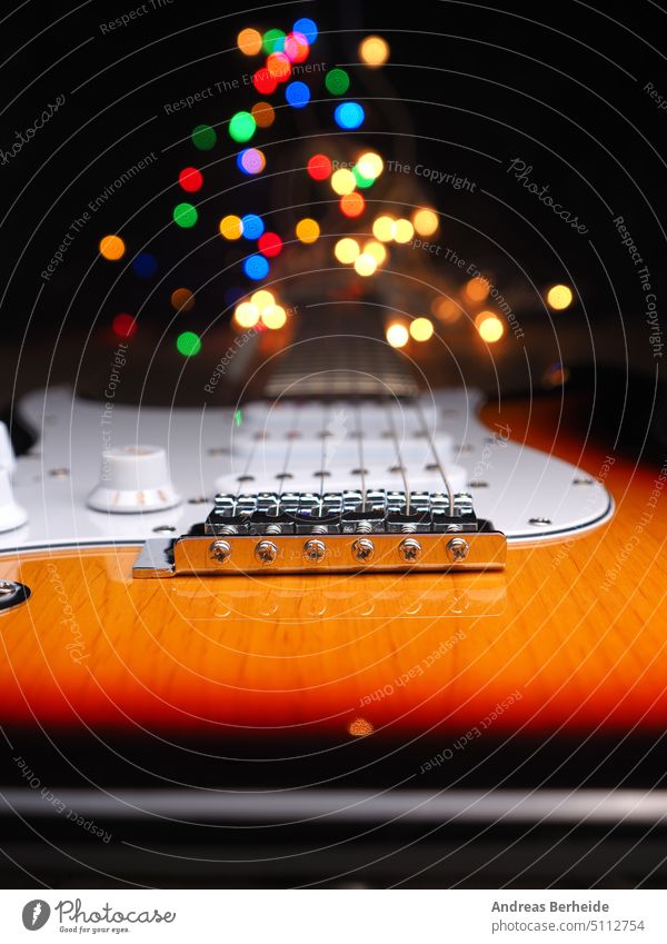 Old electric guitar with colorful Christmas lights as background Song Professional gifts Glittering wooden Neck Festive Paper chain Listening clearer Connect